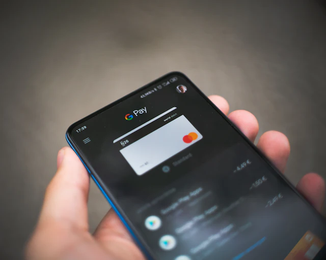 Hand holding a smartphone showing a digital payment card