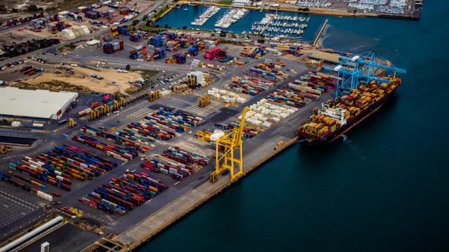 Aerial view of a container port with a cargo ship at the quay